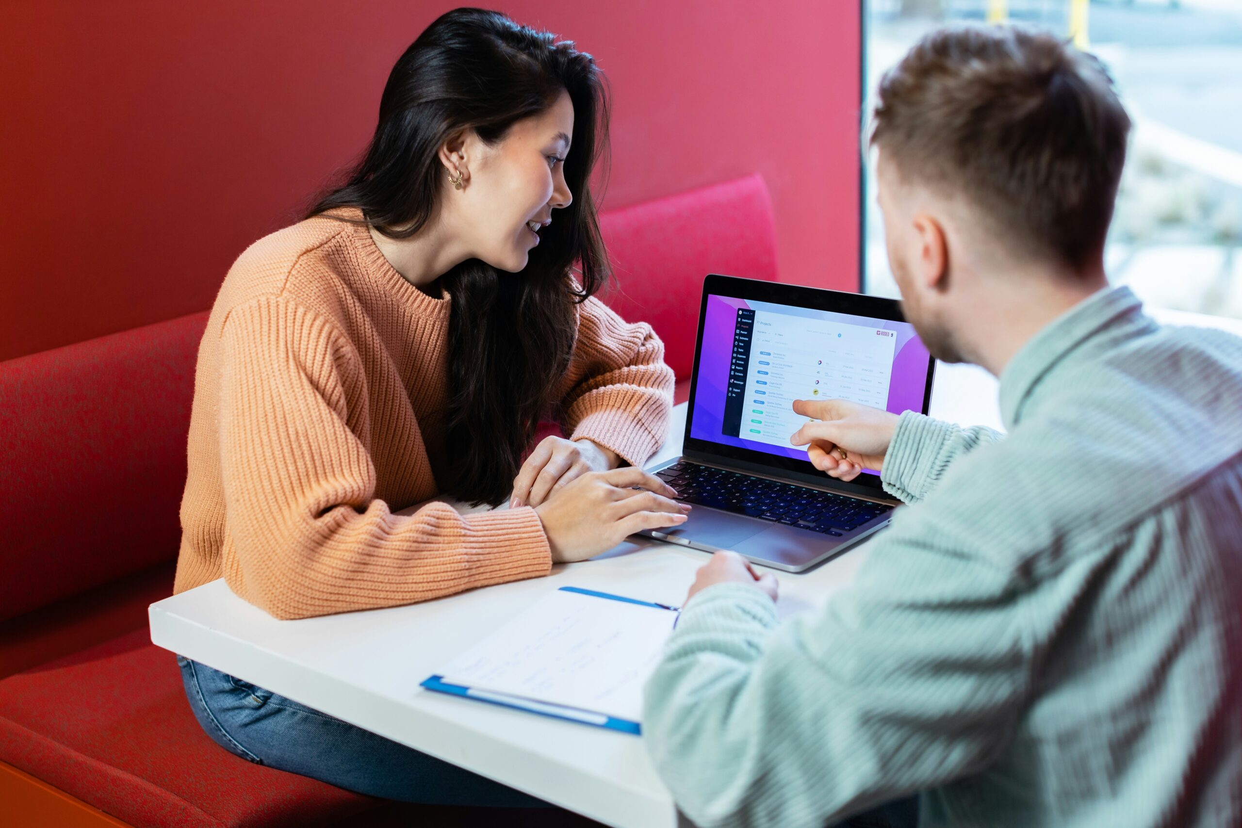 man and a woman sitting at a table with a laptop