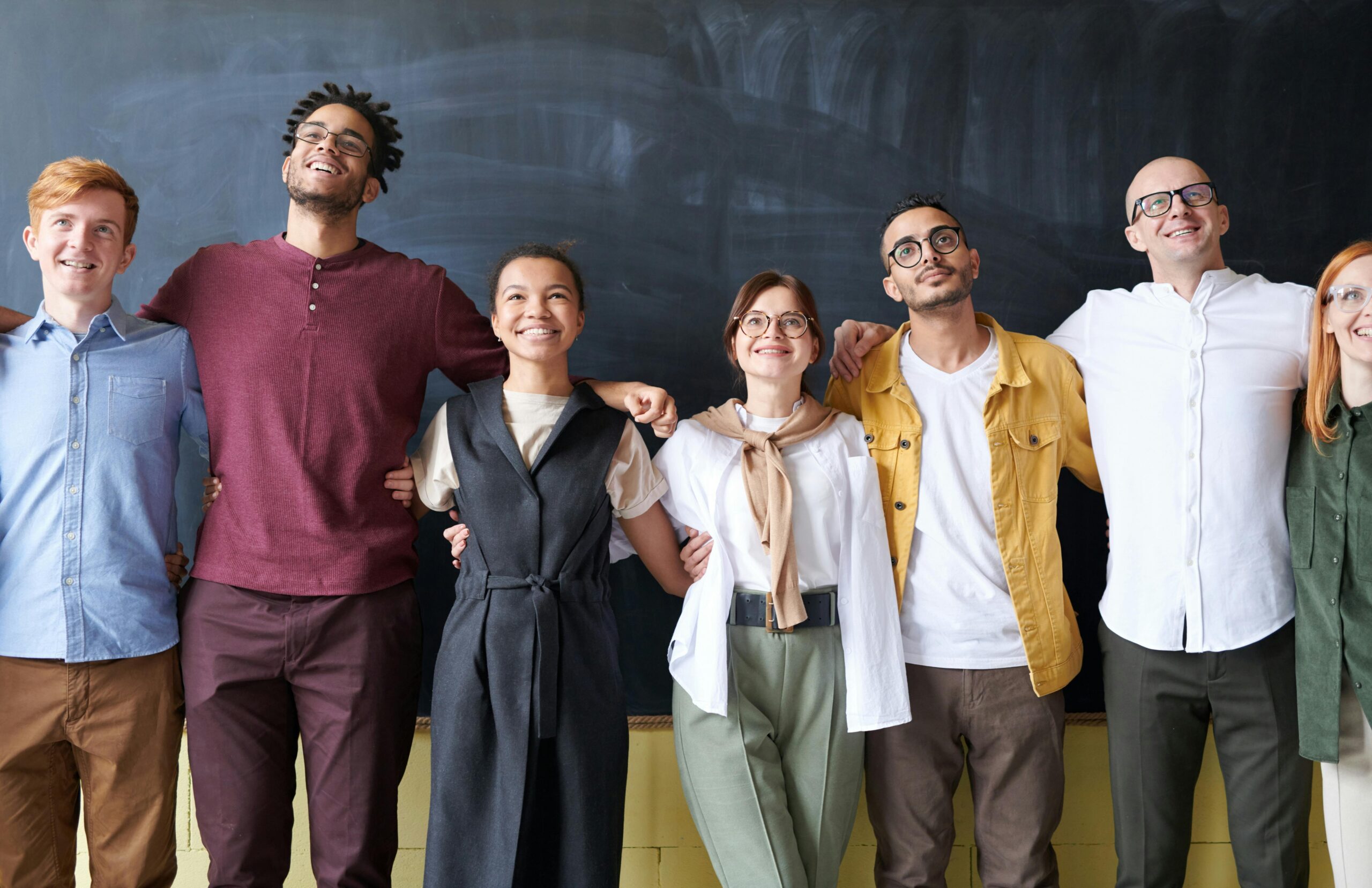 A group of people standing in front of a blackboard.